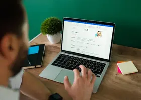 Uomo al computer che scrive e struttura il proprio curriculum vitae