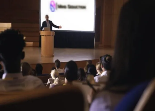Relatore esperto parla a un pubblico sul seminario su seduzione, mindset e emozioni