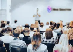Speaker con microfono mentre presenta contenuti a un pubblico interessato durante un evento relazionale