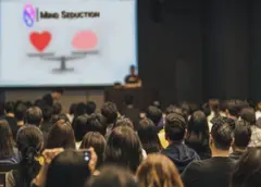 Speaker durante evento relazionale mentre mostra contenuti su monitor al pubblico